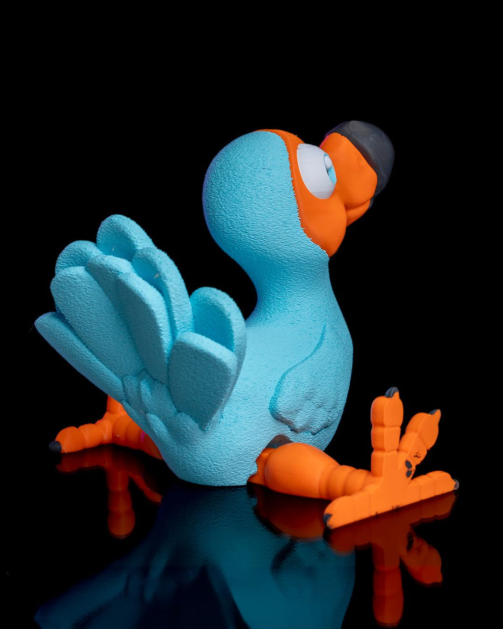 Articulated Dodo 3D printed toy in blue and orange with movable wings and legs by 3DPRINTSWA for playful display and fidgeting