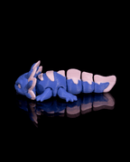 Blue and pink dragon-like creature toy on a black background