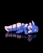 Blue and white toy dragon on a black background