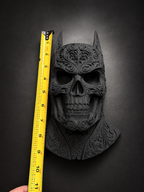 Batman skull decor photographed beside a yellow tape measure for height reference.