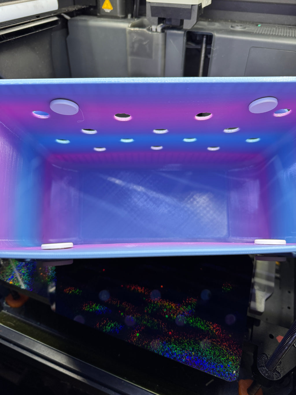 Interior view of the blue and purple tote showing its open compartment and handle attachment buttons.