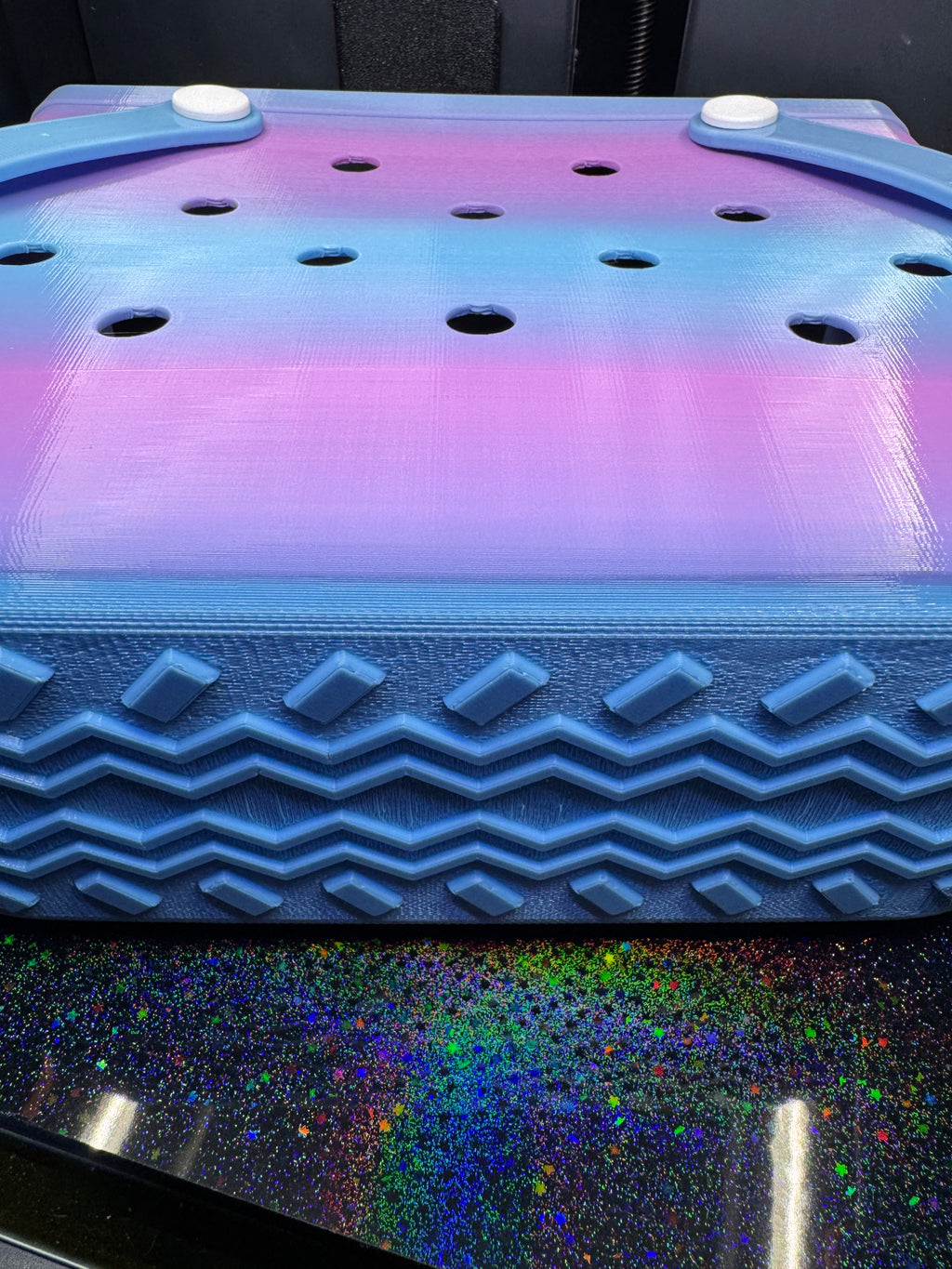 Close-up of the blue and purple tote's perforated side and textured zigzag base.