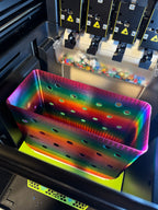 Angled overhead view of a rainbow tote body on the printer showing the open interior and circular side openings.