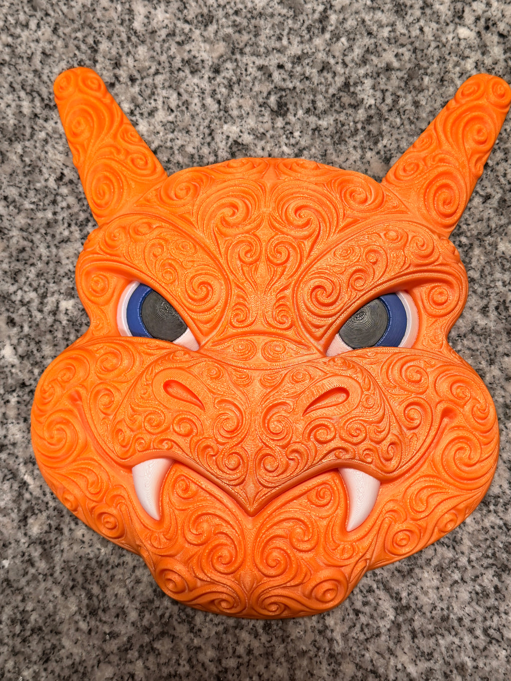 Full front view of orange Charizard wall art with ornate swirls, blue eyes, and white fangs.