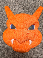 Full front view of orange Charizard wall art with ornate swirls, blue eyes, and white fangs.