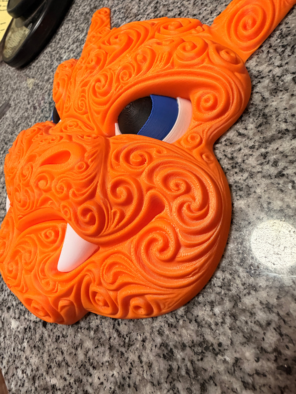 Angled close-up of Charizard wall decor showing its sculpted snout, blue eye, and raised orange filigree.
