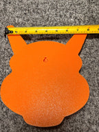 Back of the orange Charizard plaque showing its built-in keyhole hanging slot and a horizontal tape measure.