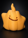 Front view of the orange Ditto jack-o'-lantern with a smiling cutout face and curved stem lid.