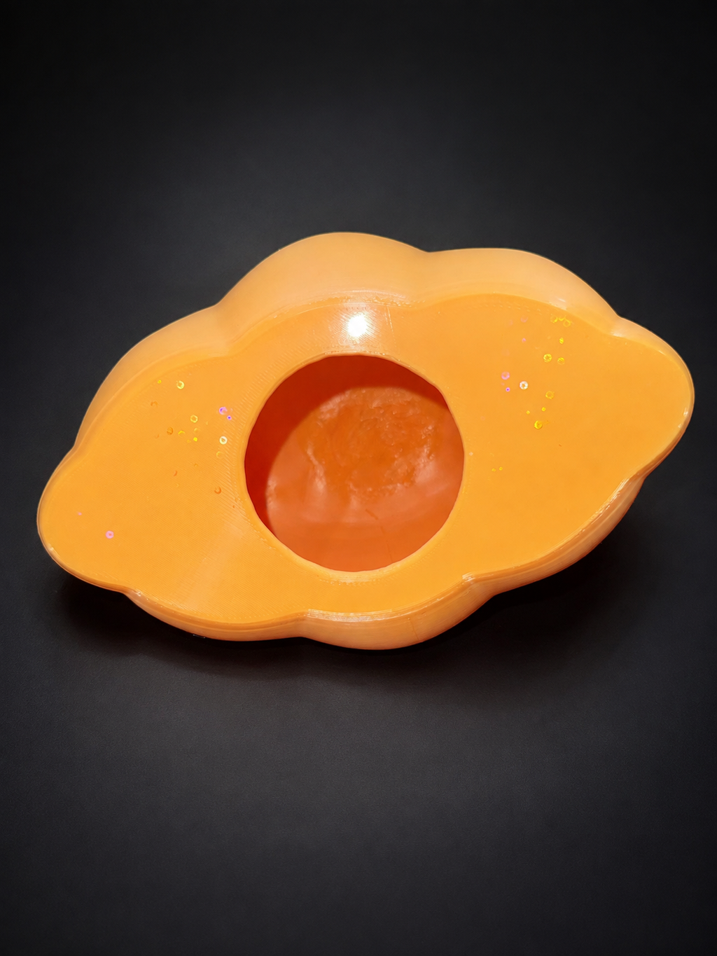 View into the hollow orange Ditto lantern with the lid removed, showing its circular opening.