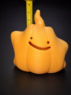 Ditto pumpkin lantern photographed beside a vertical tape measure for height reference.
