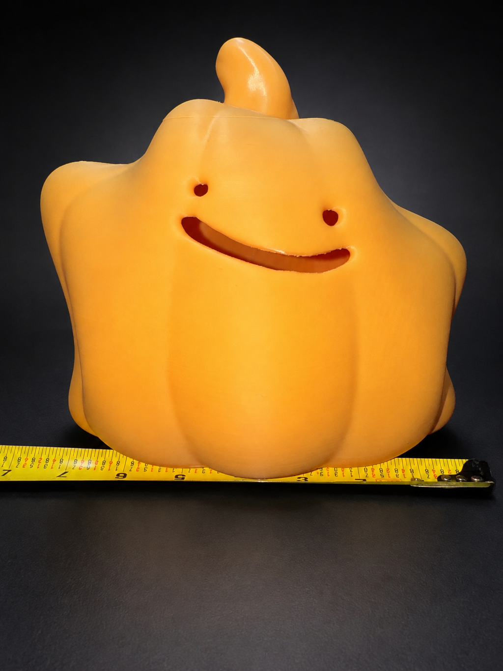 Front view of Ditto jack-o'-lantern with a horizontal tape measure beneath it for width reference.