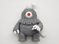 Front view of gray Dusclops wall decor with ornate scrollwork, white hands, and a red-centered eye.