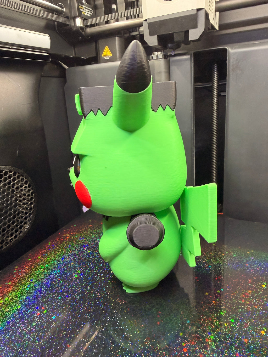 Side profile of Frankenstein Pikachu showing its head, neck bolt, and lightning-shaped tail.