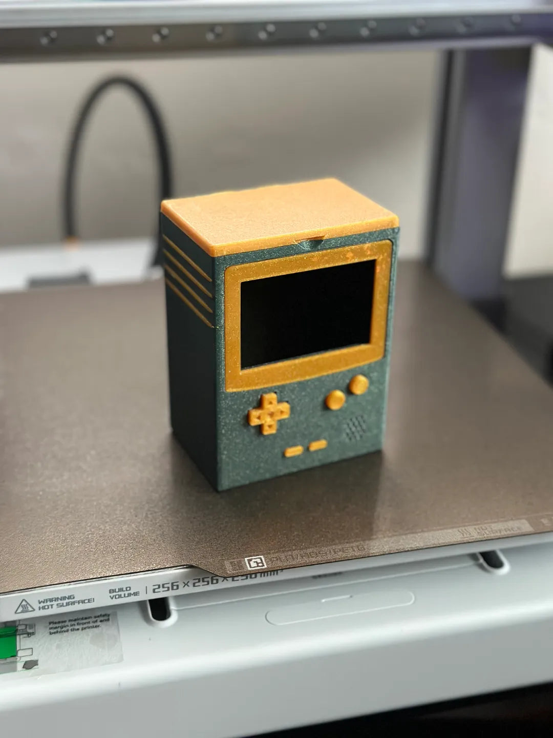 Green and gold Game Boy-inspired deck box with its lid closed.