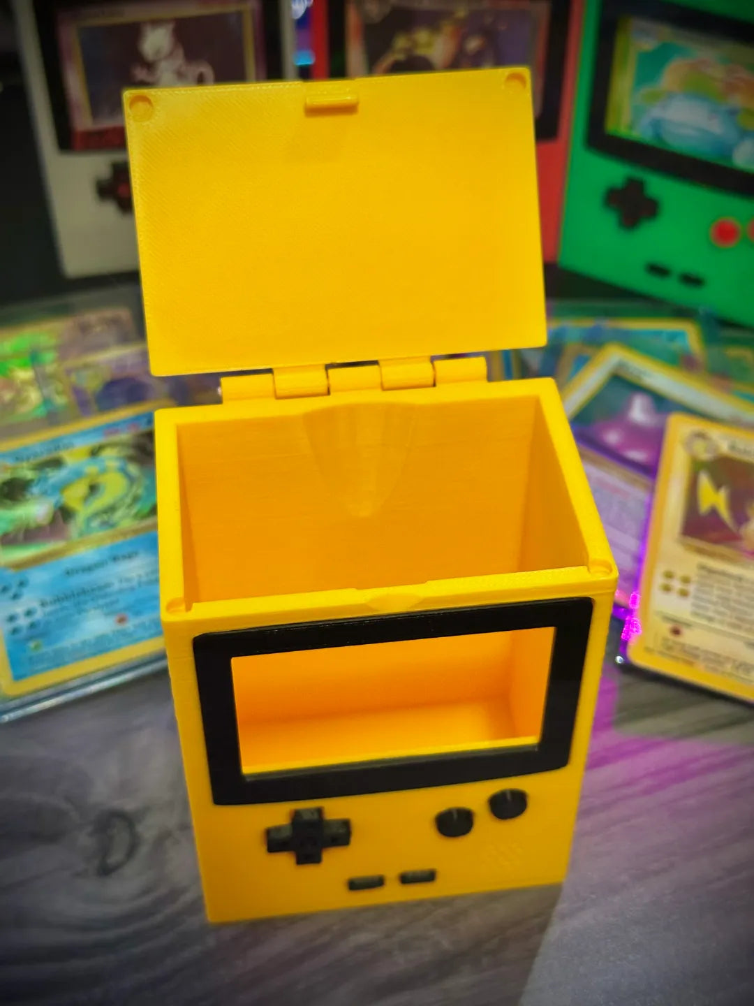 Yellow deck box with its hinged lid open, showing the card storage compartment.