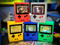 Game Boy-inspired deck boxes in red, gray, yellow, blue, and green with display cards.