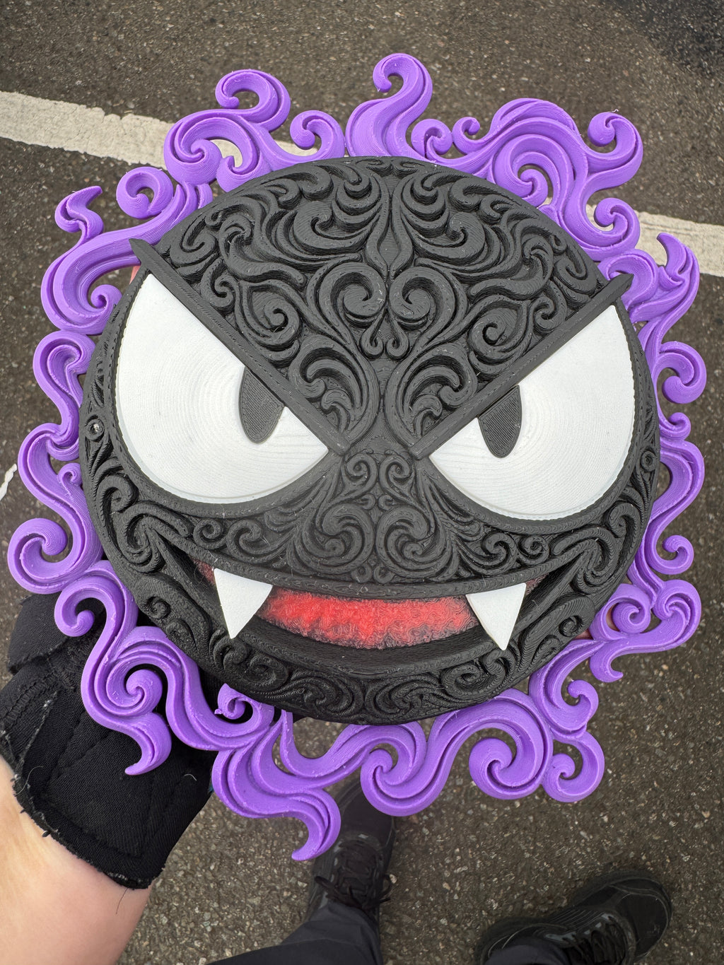 Gastly wall art held outdoors, showing its raised black filigree and purple ghostly border.
