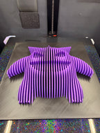 Angled view of Gengar optical illusion wall art lying flat, showing its dimensional purple silhouette.