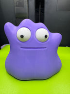 Front view of purple Googly-Eyed Ditto with large movable white eyes and black pupils on a green printer plate.