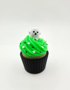 Green decorative cupcake with white ghost topper and black wrapper.