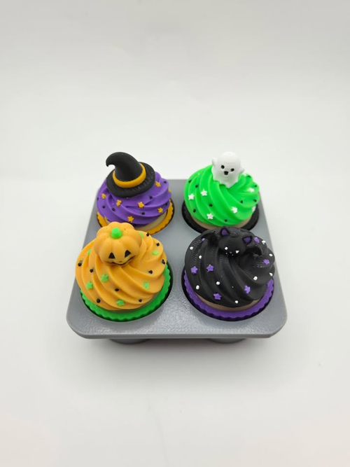 Complete Halloween cupcake set with four decorative cupcake figures on a gray display tray.