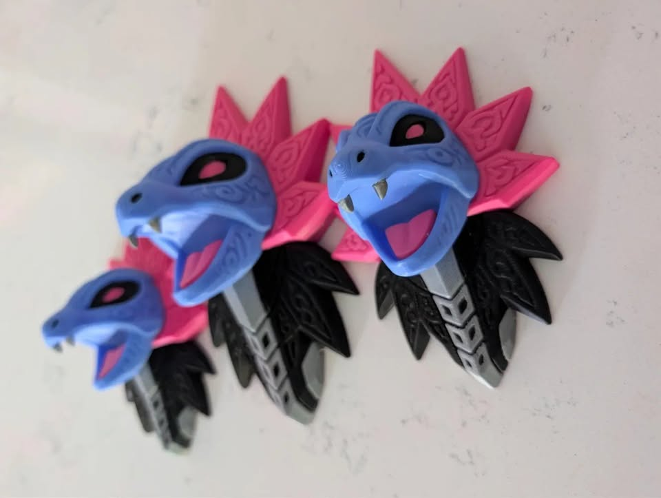 Angled view of Iron Jugulis Pokémon wall art showing three dimensional blue heads and magenta, black and white details.
