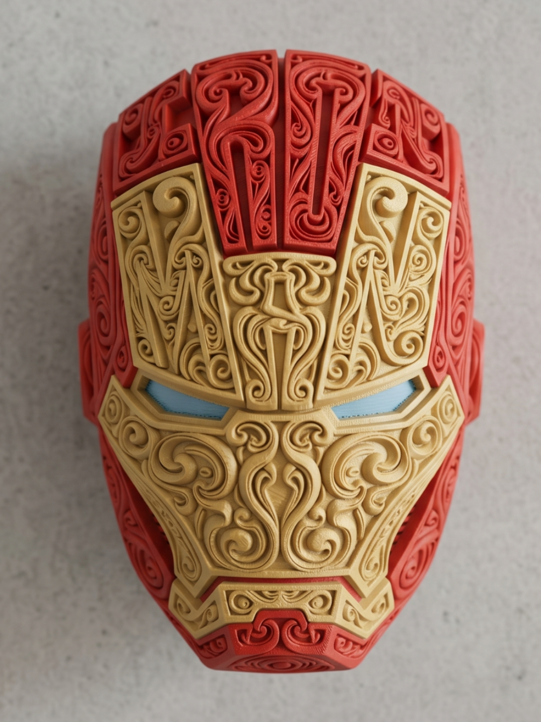 Red and gold Iron Man wall art with raised ornate filigree and light blue eyes on a light background.