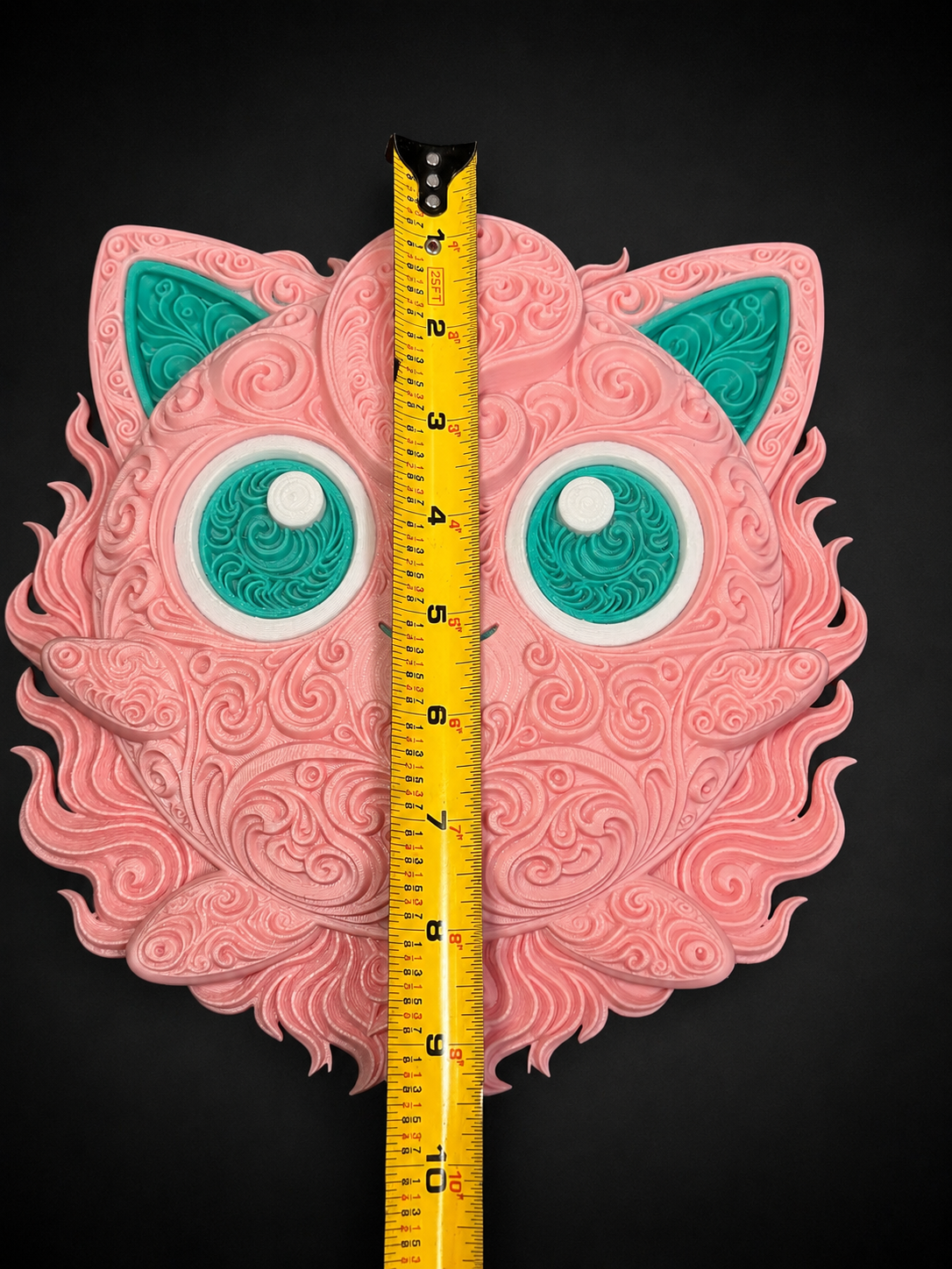 Front of pink and teal Jigglypuff wall art beside a vertical tape measure showing its approximate height.