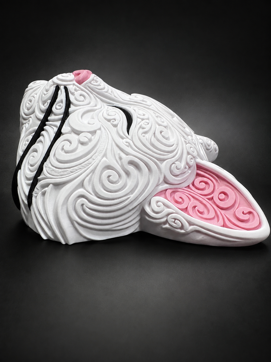 Side view of white Korin wall art showing its dimensional profile, pink ear, and raised filigree details.