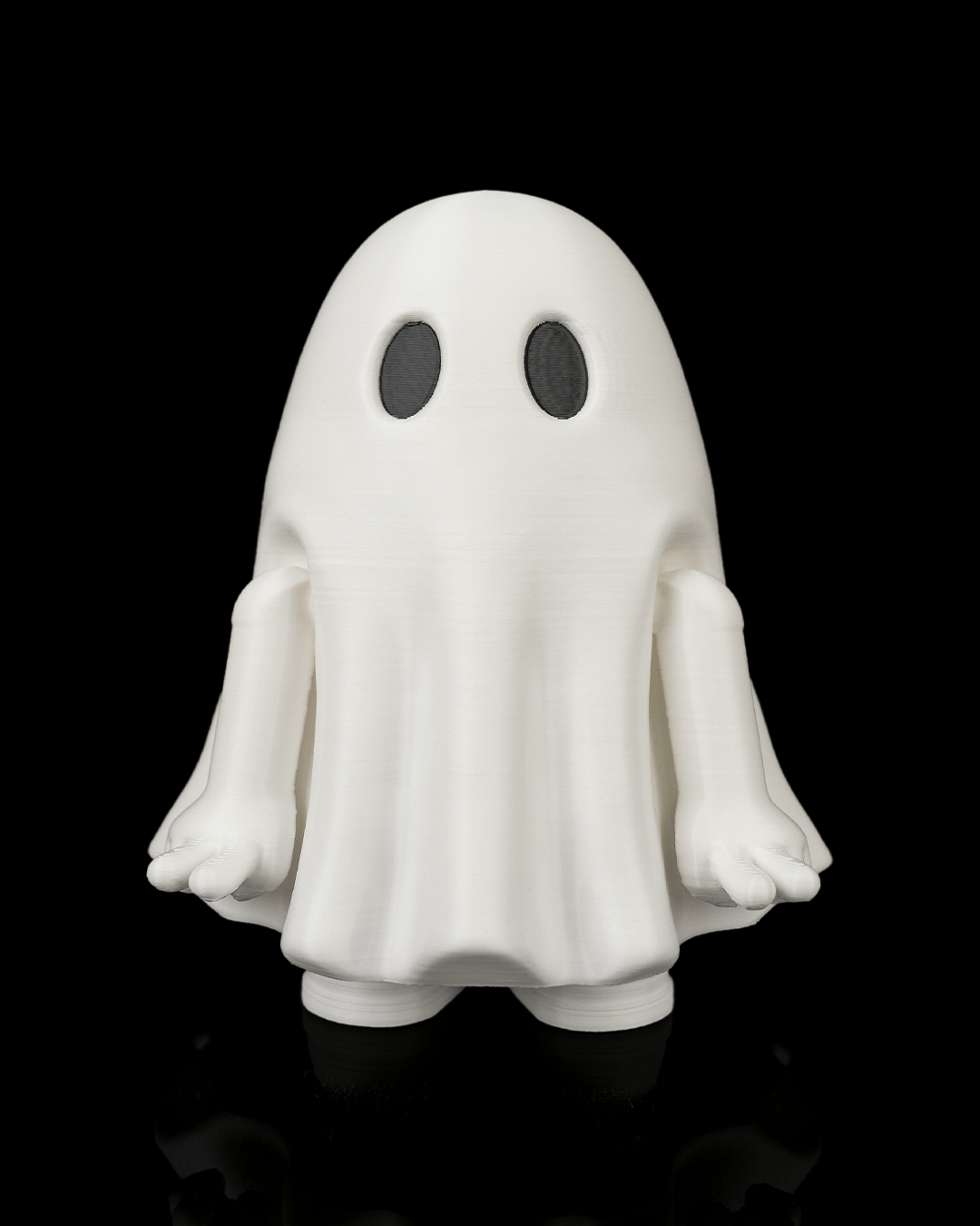 Front view of a white Mood Ghost desk toy with black eyes, lowered arms, and feet visible against a black background.