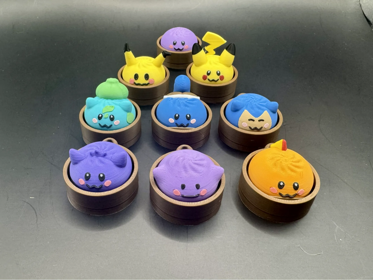 Group of colorful Pokémon dumpling clickers in brown steamer-style bases, showing several character designs.
