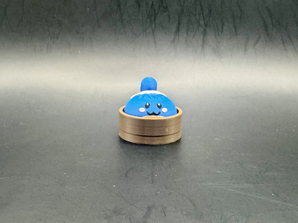 Blue Squirtle dumpling clicker with pink cheeks in a brown steamer-style base.