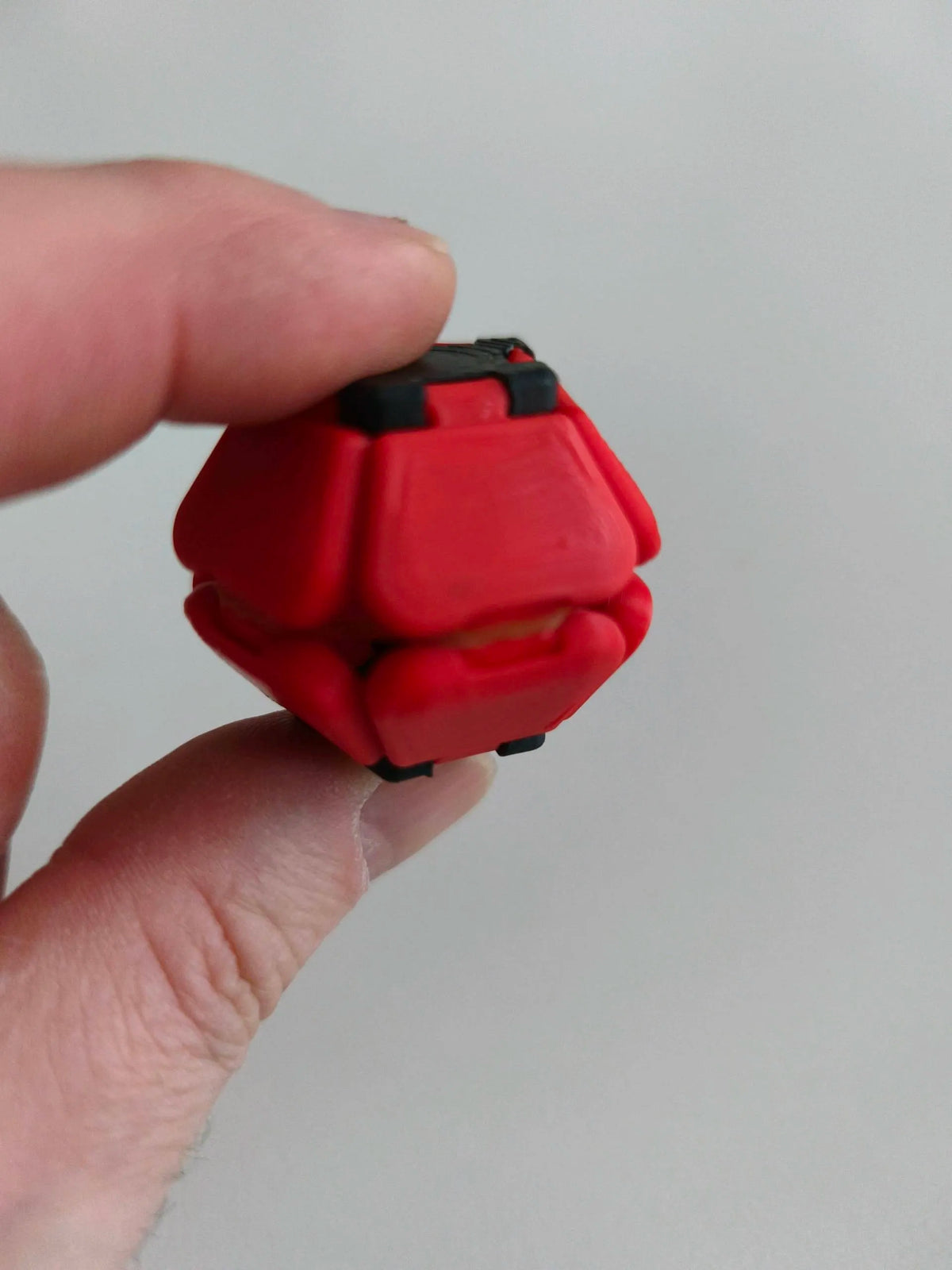 Red Pop Fidget held between fingers