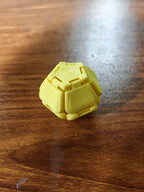 Yellow Pop Fidget on a wooden surface