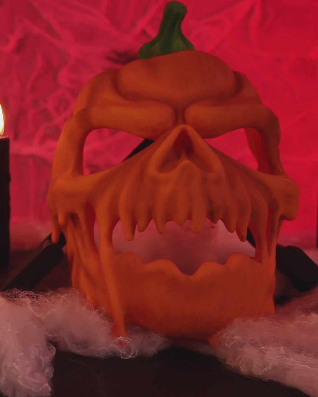 Pumpkin Halloween Mask demonstration showing its orange carved skull design and green stem.
