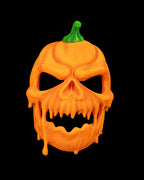 Front view of orange pumpkin skull Halloween mask with green stem, jagged teeth, and open eyes and mouth.