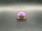 Regular purple dumpling clicker with a smiling face and pink cheeks in a brown steamer-style base.
