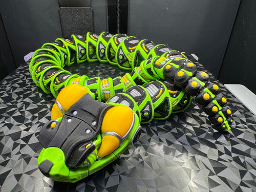 Coiled articulated robotic rattlesnake with lime green body, black panels, yellow head accents, and silver details.