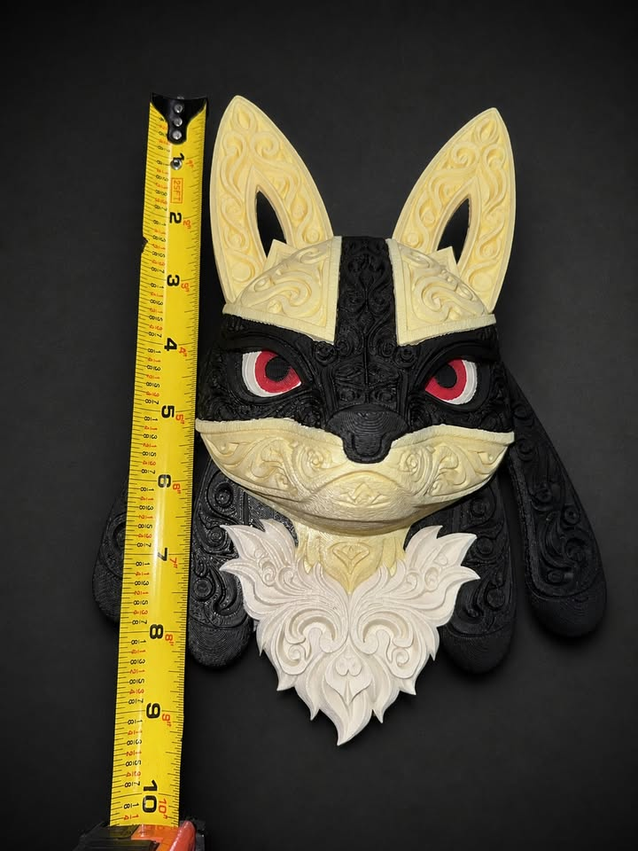 Front of pale yellow, black, and white Shiny Lucario wall art beside a vertical tape measure.
