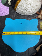 Flat blue back of Shiny Mew wall art showing a keyhole hanging slot and a horizontal tape measure across its width.