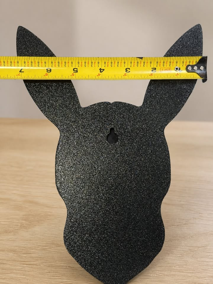 Black back of Shiny Umbreon wall art showing a keyhole slot and a horizontal tape measure across its ears.