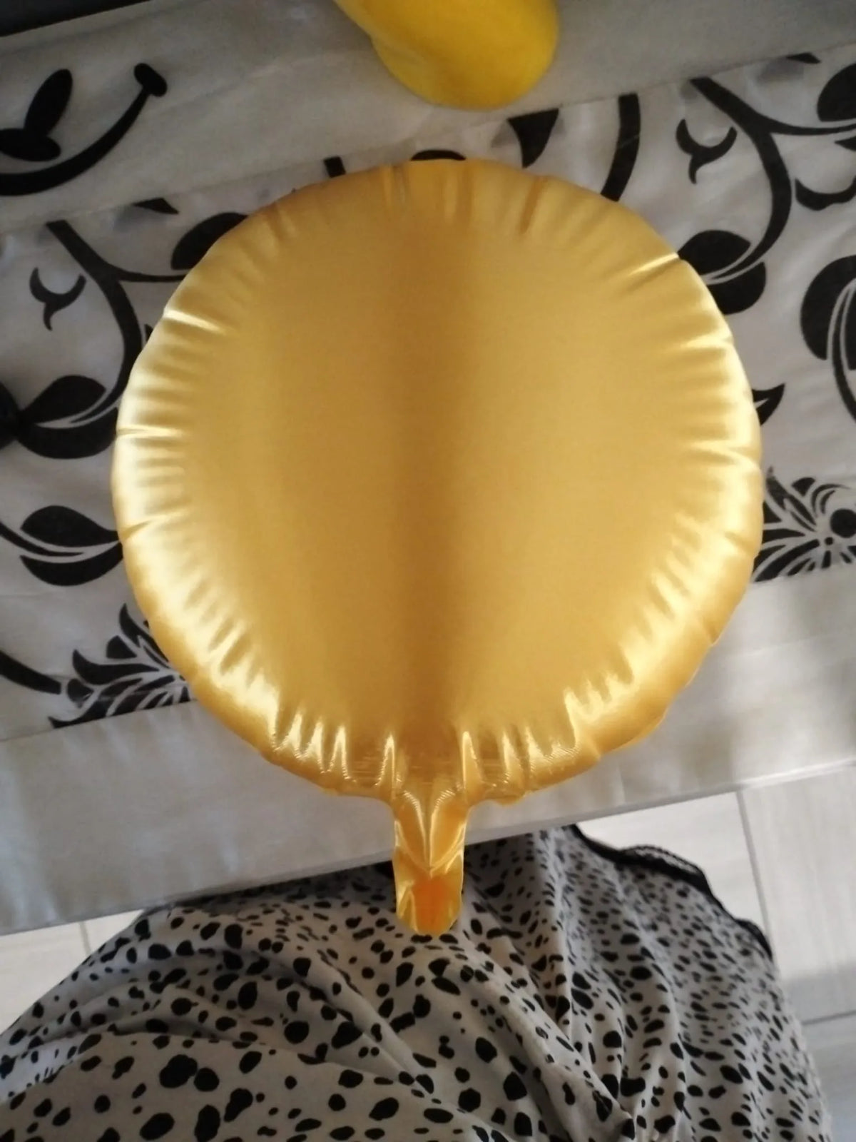 Plain gold-colored balloon form showing the rounded surface and sculpted edge without a smiley face.