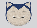 Front detail of cream and dark blue Snorlax wall art showing raised ornate scrollwork, closed eyes, and a smiling mouth.