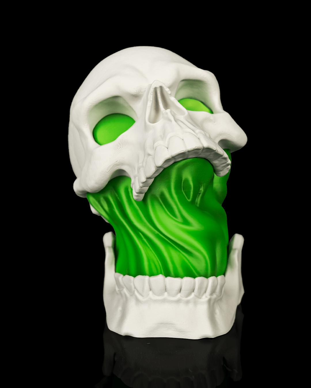 White Toxic Skull Lamp with an open jaw and bright green flowing center, shown from the front dim view against black.