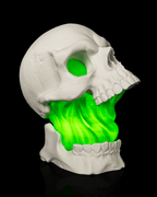 White Toxic Skull Lamp with an open jaw and bright green flowing center, shown from the side right view against black.