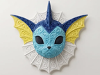 Vaporeon filigree wall art with a light blue face, dark blue crest, yellow ear fins, and a white neck frill on a light wall.