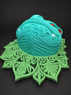 Venusaur wall art with teal raised filigree, red eyes and ear accents, white teeth, and green leafy scrollwork, shown from the low angle view.